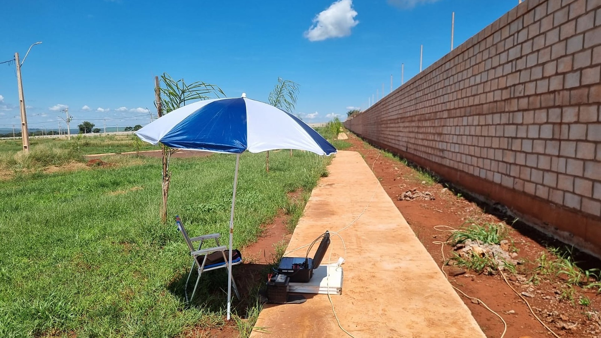 Estação de aquisição geofísica da Aqua Liber montada ao lado de um muro em área urbana — o estudo de locação define o ponto do poço antes do pedido de licença de execução
